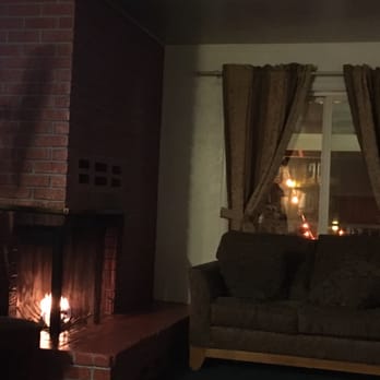 Robinhood Resort - View of the fireplace and couch that's located next to the door of the room. The window overlooks a small courtyard. - Big Bear Lake, CA