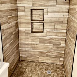 Alpha Tile - Custom shower with wood plank tile and two shampoo niches.