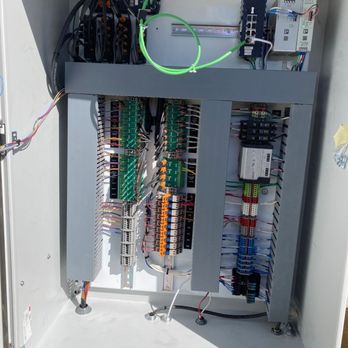 RCI Electric - An open, light gray electrical enclosure reveals organized rows of colorful terminal blocks, circuit boards, and wiring... - Electricians Near Me - Loveland, Colorado