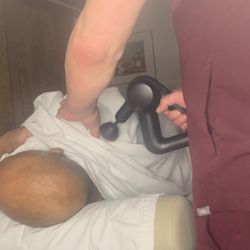 Arlington Massage - Various tools are used to aid with massage; in this instance a theragun is being used.