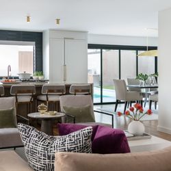 Romo Remodeling - Open kitchen and living area with a five-panel glass door connecting the interior directly to the pool and outdoor living space.