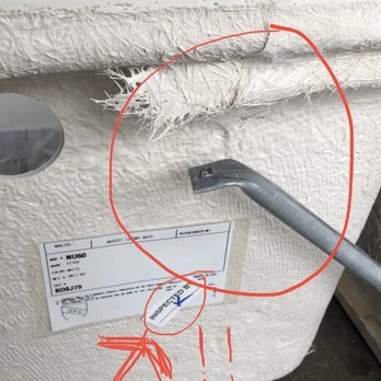 Ferguson Home - Inspected!? - A white appliance, possibly a freezer or refrigerator, has a tear at the top with frayed edges. A red circle and arrow are drawn on the image, highlighting the damage. - Kitchen & Bath Near Me - Oak Brook, Illinois