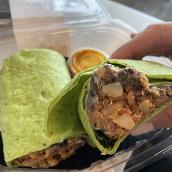 JuiceLand - a hand holding a burrito in a plastic container - Juice Bars & Smoothies Near Me - Austin, Texas JuiceLand - a hand holding a burrito in a plastic container - Juice Bars & Smoothies Near Me - Austin, Texas