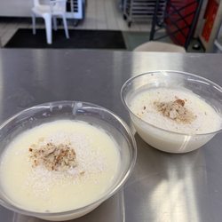 Tiny cups of delicious milk pudding topped with finely shaved coconut and possibly almonds.