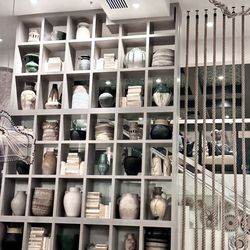 Copra - Beautiful floor to ceiling shelves of pottery leading to the second floor dining.