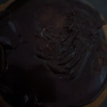 Honey Dew Donuts - a hand holding a chocolate donut - Donuts Near Me - Pawtucket, Rhode Island