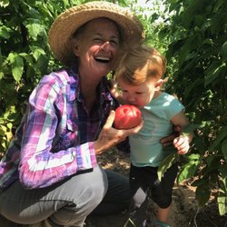 Sunshine Herbs - Linda and her granddaughter, with tomatoes in the garden.