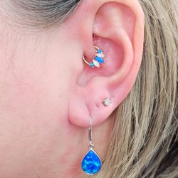 Abnormal Gifts - Daith piercing with a white & toquoise fire opal gold hoop.