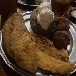 Catfish dinner with baked potato tons of sour cream and butter Huge hush puppies homemade tartar and ranch