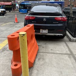 Employee parking on the sidewalk illegally in an active driveway