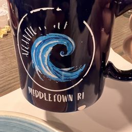 Yummy coffee - A black ceramic mug featuring a blue wave illustration and the text 'Middletown RI' and 'Atlantic,' likely representing a location or business in Rhode Island.