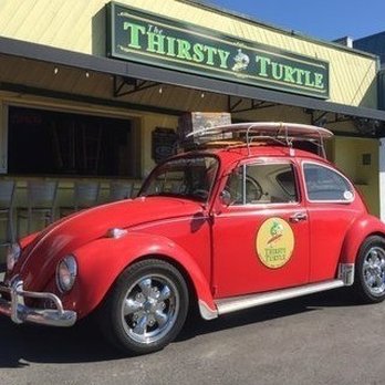 The Thirsty Turtle - a red vw beetle parked in front of a store - Bars Near Me - Sarasota, Florida