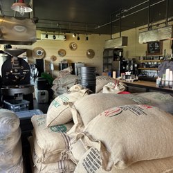 Trager Brothers Coffee - The coffee counter is in the back with the coffee bean sacks stack around waiting to be processed.