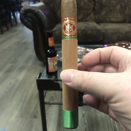 a hand holding a cigar a hand holding a cigar