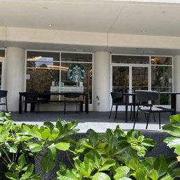 the outside of a coffee shop with tables and chairs the outside of a coffee shop with tables and chairs