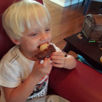 A.M. Donuts -  a young boy eating a donut - Donuts Near Me - Fayetteville, Arkansas