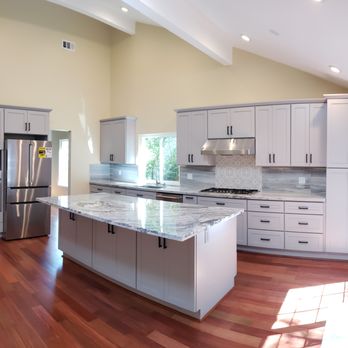 Ashkanz - a large kitchen with a center island - General Contractors Near Me