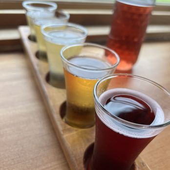 Finnriver Farm & Cidery - Cider flight, with the "kiss of blueberry" cider in the background that was a clear favorite - Cideries Near Me - Chimacum, Washington Finnriver Farm & Cidery - Cider flight, with the "kiss of blueberry" cider in the background that was a clear favorite - Cideries Near Me - Chimacum, Washington