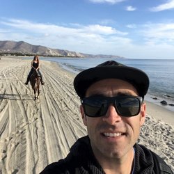 Betto - Riding a horse on the beach along the water.l