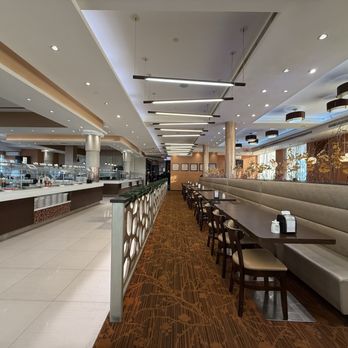 The Buffet - Seating, more behind the long benches and other side of the food stations - Buffets Near Me - College Point, New York