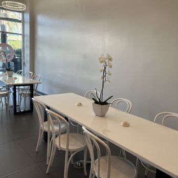 Lady M Cake Boutique - Tables with one potted orchid - Desserts Near Me - Irvine, California Lady M Cake Boutique - Tables with one potted orchid - Desserts Near Me - Irvine, California