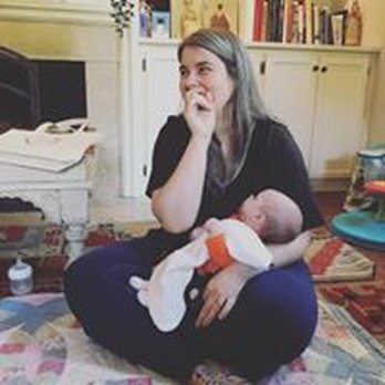 Zoe Etkin Embodiment Doula - Zoe with a client's baby, facilitating a Mama Circle gathering - Doulas Near Me Zoe Etkin Embodiment Doula - Zoe with a client's baby, facilitating a Mama Circle gathering - Doulas Near Me