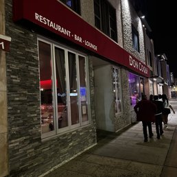 people walking down a sidewalk at night