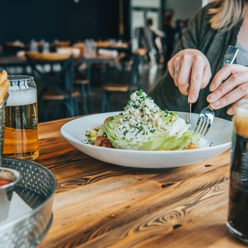 Boathouse Saranac Lake Pub - a woman eating a salad - Gastropubs Near Me - Saranac Lake, New York Boathouse Saranac Lake Pub - a woman eating a salad - Gastropubs Near Me - Saranac Lake, New York