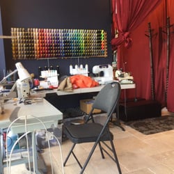 Tailoring desk at the front of the shop with the changing room beside it.