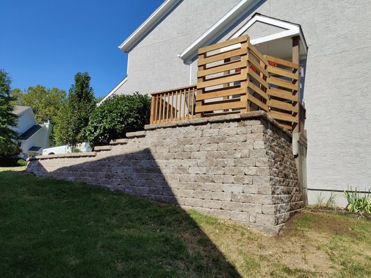 Retaining wall in front of home - We removed a rotting timber wall and reinstalled a Versa Lok retaining wall. On top of the wall we installed a privacy fence and small patio to give the homeowner a private space to sit outside.