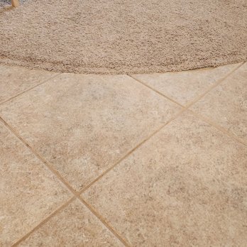 Coconut Cleaning - After - The image shows beige ceramic tiles with grout lines and a textured, light brown rug at the top edge. - Carpet Cleaning Near Me - Chandler, Arizona