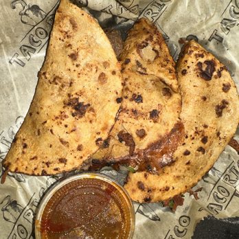 Tacomoli - a plate of food with sauce - Food Delivery Services Near Me Tacomoli - a plate of food with sauce - Food Delivery Services Near Me