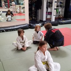 Excellent group of kids learning to stretch and meditate at the beginning of an afternoon Kenpo class