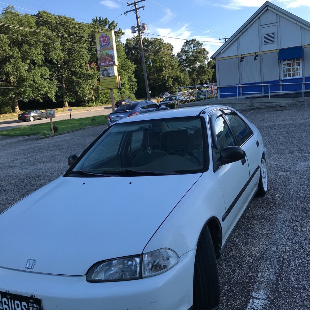 a white car parked in a parking lot a white car parked in a parking lot