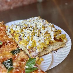 MAMA'S TOO! - The Elote - airy and crispy focaccia style topped with roasted sweet corn, cotija cheese, crema, and guajillo, ancho, chili piquin powder