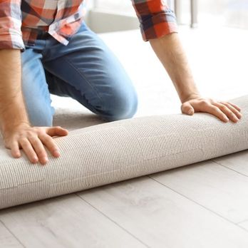 Minot Flooring - a man rolling up a rug - Carpet Installation Near Me - Minot, North Dakota Minot Flooring - a man rolling up a rug - Carpet Installation Near Me - Minot, North Dakota