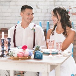 Studio 215 - Bride and groom posing against one of the large exposed industrial walls