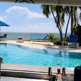 The photo has the view from the pool bar of the pool and the bay.