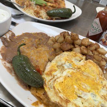 Vineyard Cafe - Chilaquiles Over Hard Eggs and Red potatoes rear plate is Huevos Rancheros with hash browns come with an order of pancakes - Breakfast & Brunch Near Me - Oxnard, California Vineyard Cafe - Chilaquiles Over Hard Eggs and Red potatoes rear plate is Huevos Rancheros with hash browns come with an order of pancakes - Breakfast & Brunch Near Me - Oxnard, California
