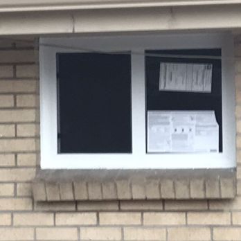 All About Glass of Colorado - A newly installed horizontal slider window with white vinyl trim is set into a beige brick wall... - Glass & Mirrors Near Me