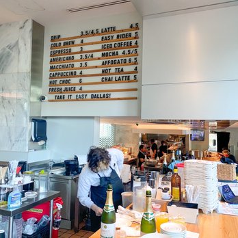 Overeasy - a restaurant counter with a menu on the wall - New American Near Me - Dallas, Texas
