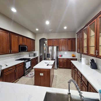 Angel Painting - Elegant kitchen showcasing beautifully refinished dark wood cabinets, bright quartz countertops, stainless steel appliances, ... - Painters Near Me Angel Painting - Elegant kitchen showcasing beautifully refinished dark wood cabinets, bright quartz countertops, stainless steel appliances, ... - Painters Near Me