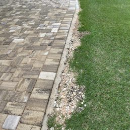 Leftover rubble on neighbor's side. Additionally, they left the demo'ed rusty iron cement inlay and unleveled pavers.