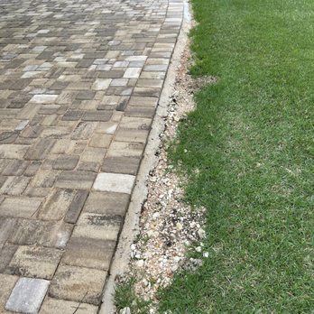 Allied Outdoor Solutions - Leftover rubble on neighbor's side. Additionally, they left the demo'ed rusty iron cement inlay and unleveled pavers. - Masonry/Concrete Near Me - Austin, Texas