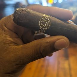 a hand holding a cigar