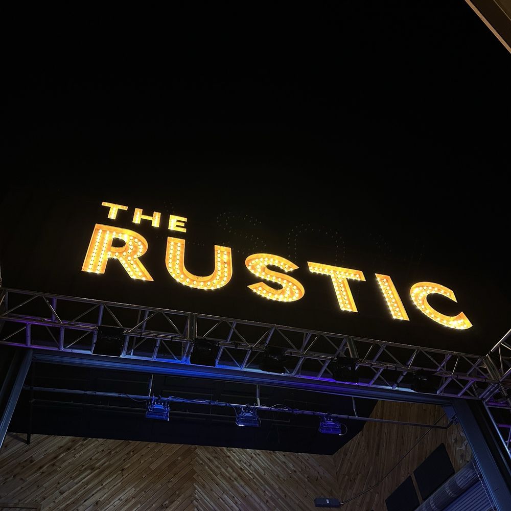 The Rustic - Outdoor view of the sign and stage - New American Near Me - Dallas, Texas