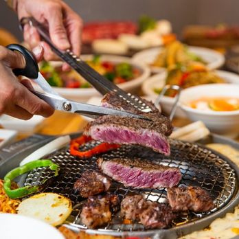 Kang's Kitchen - a person cutting a steak on a grill - Barbeque Near Me - Las Vegas, Nevada Kang's Kitchen - a person cutting a steak on a grill - Barbeque Near Me - Las Vegas, Nevada
