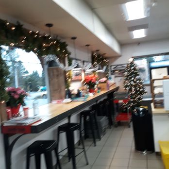 Sandy Shell Station - They offer a nice place to sit and eat their delicious food from their deli. Best Breakfast burrito! - A convenience store interior decorated for Christmas, featuring a small Christmas tree, poinsettia plants, and holiday garlands along the window. - Gas Stations Near Me - Sandy, Oregon
