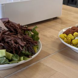 Beef schwarma with greens and mezze on the left. Chicken with rice and lots of goodies on the right. Beef schwarma with greens and mezze on the left. Chicken with rice and lots of goodies on the right.