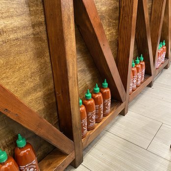 Pho Manhasset - a row of bottles of hot sauce - Noodles Near Me - Manhasset, New York
